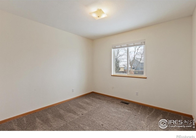 spare room featuring carpet floors, baseboards, and visible vents