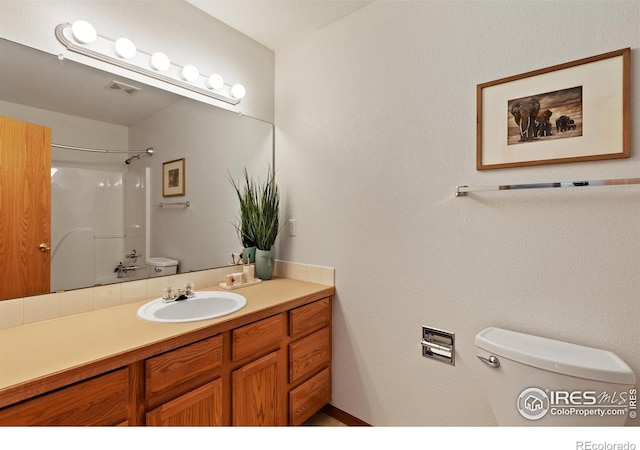 bathroom featuring toilet, visible vents, a shower, and vanity