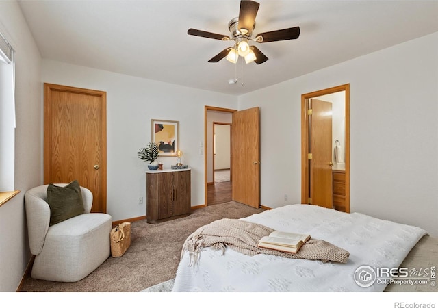 bedroom featuring baseboards, ensuite bathroom, a ceiling fan, and light colored carpet