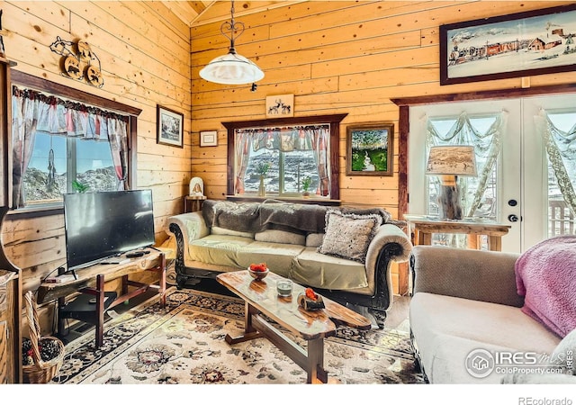 living room featuring wooden walls, vaulted ceiling, and french doors