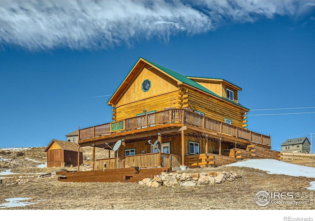 view of front of home with a deck and log exterior