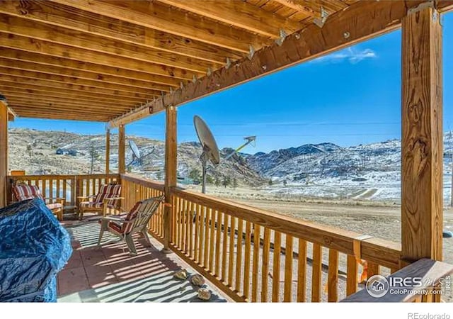 snow covered deck featuring a mountain view