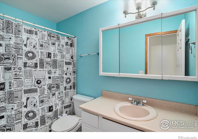 full bathroom featuring toilet, a shower with shower curtain, and vanity