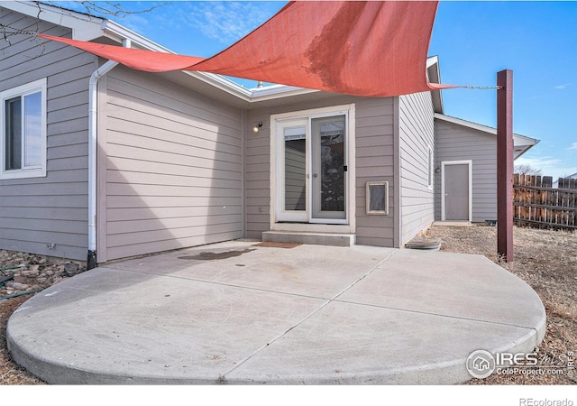 rear view of property featuring a patio and fence