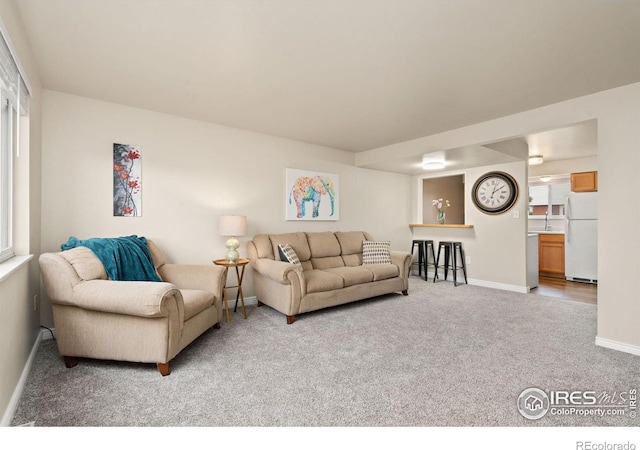 living room with light carpet and baseboards