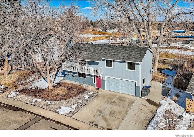 view of front of house with a balcony, central air condition unit, driveway, and a garage