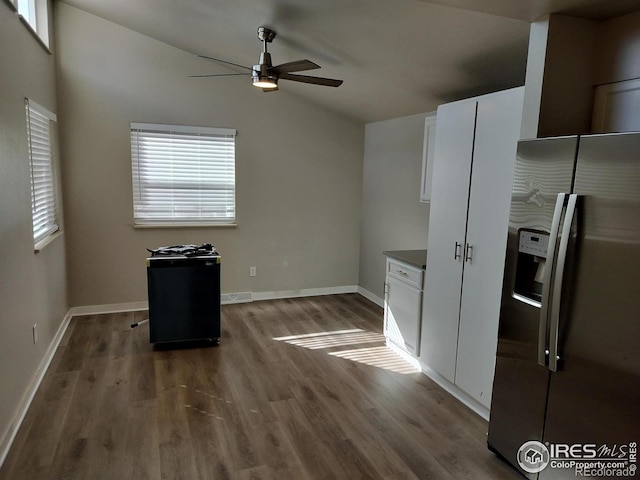 kitchen featuring lofted ceiling, wood finished floors, visible vents, white cabinets, and stainless steel fridge with ice dispenser