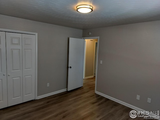 unfurnished bedroom with a closet, baseboards, and wood finished floors