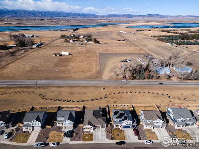 drone / aerial view featuring a residential view and a water and mountain view