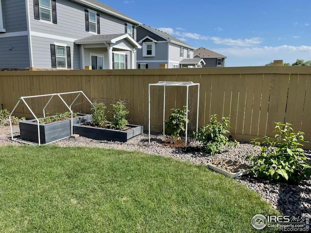 view of yard featuring fence and a vegetable garden