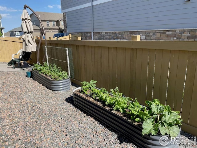 view of yard featuring fence and a vegetable garden