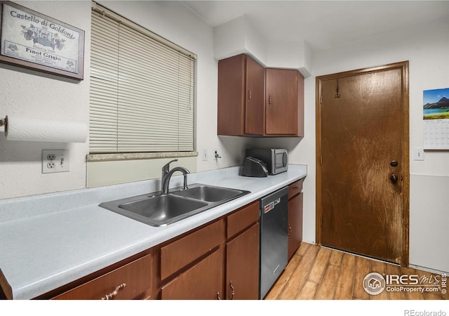 kitchen with dishwasher, stainless steel microwave, brown cabinets, light countertops, and a sink