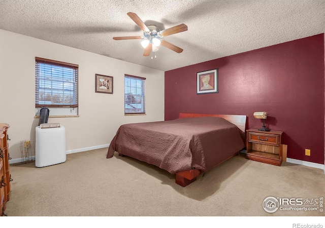 bedroom featuring a ceiling fan, carpet, a textured ceiling, and baseboards