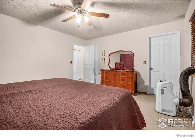 bedroom featuring light carpet, ceiling fan, and a textured ceiling