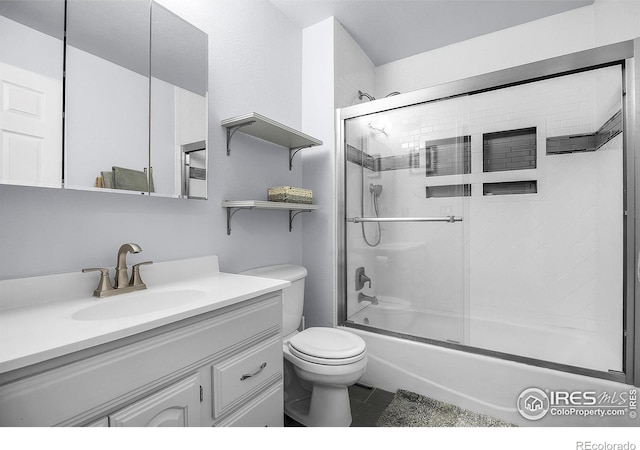 bathroom with bath / shower combo with glass door, vanity, and toilet