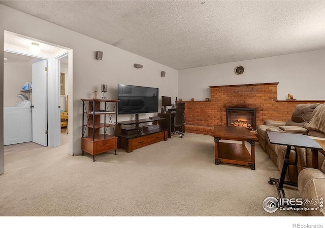 living area featuring lofted ceiling, washer / clothes dryer, a textured ceiling, and light colored carpet