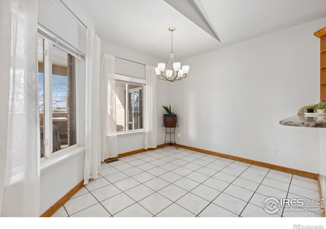 unfurnished dining area featuring light tile patterned floors, baseboards, and an inviting chandelier