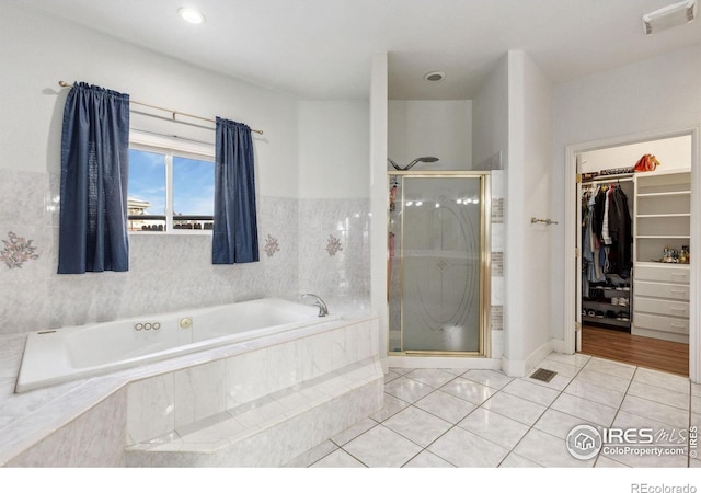 bathroom featuring visible vents, tile patterned floors, a spacious closet, a shower stall, and a bath