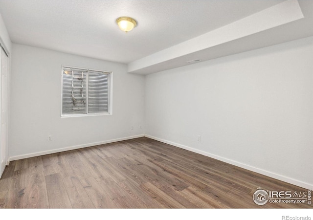 spare room with visible vents, baseboards, and wood finished floors