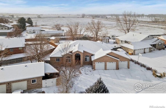 snowy aerial view featuring a residential view