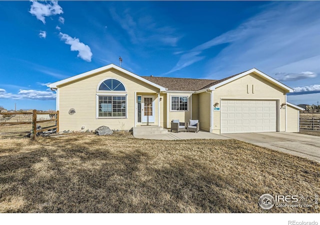 single story home featuring an attached garage, driveway, fence, and a front yard