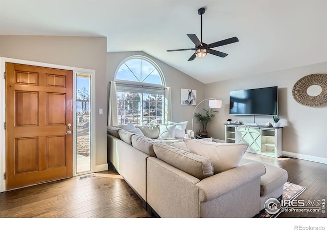 living room featuring visible vents, dark wood-type flooring, a ceiling fan, vaulted ceiling, and baseboards