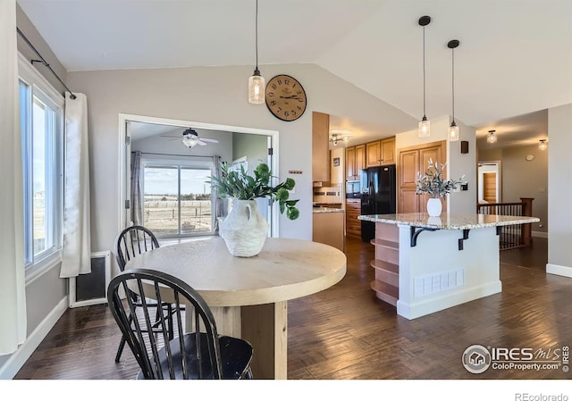 dining area with vaulted ceiling, dark wood-type flooring, and baseboards