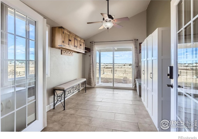 doorway to outside with lofted ceiling, a ceiling fan, and a textured wall