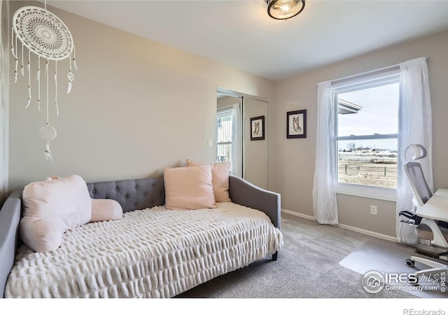 carpeted bedroom featuring a closet and baseboards