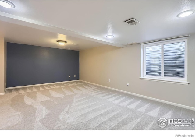 unfurnished room with baseboards, visible vents, and light colored carpet