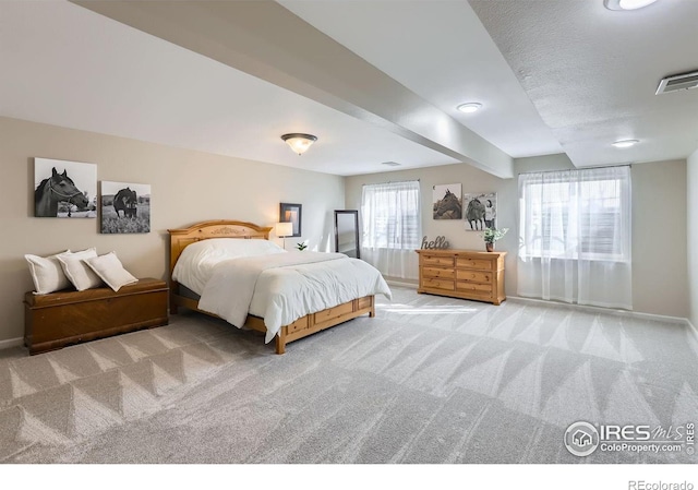 bedroom with carpet, visible vents, beamed ceiling, and baseboards