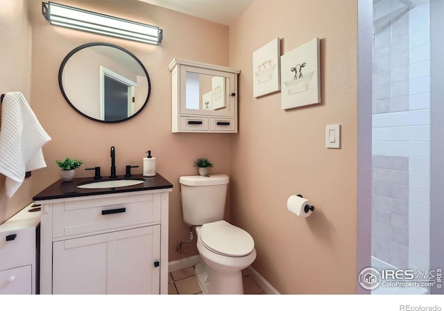 bathroom featuring baseboards, vanity, toilet, and tile patterned floors