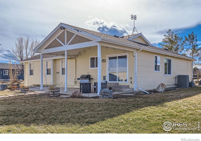 rear view of house with a patio area, a lawn, and central AC unit