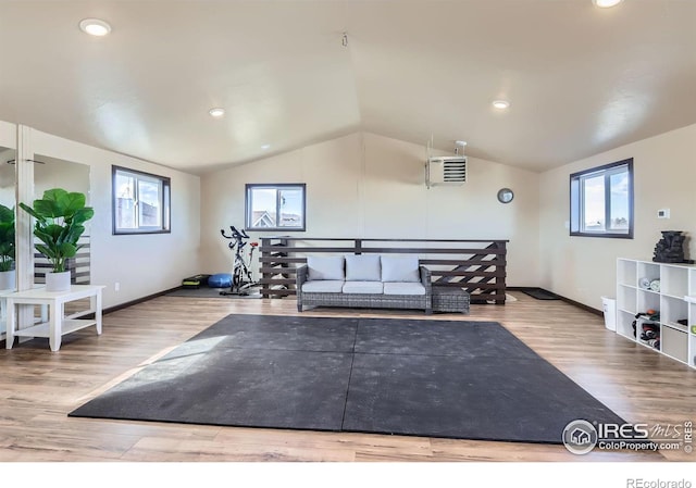 exercise room featuring vaulted ceiling, wood finished floors, a wealth of natural light, and baseboards