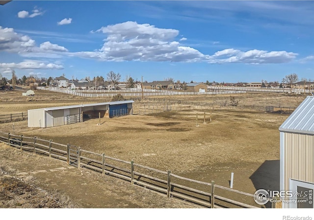 view of yard with a rural view, an outdoor structure, and an exterior structure