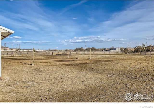 view of yard with a rural view and fence