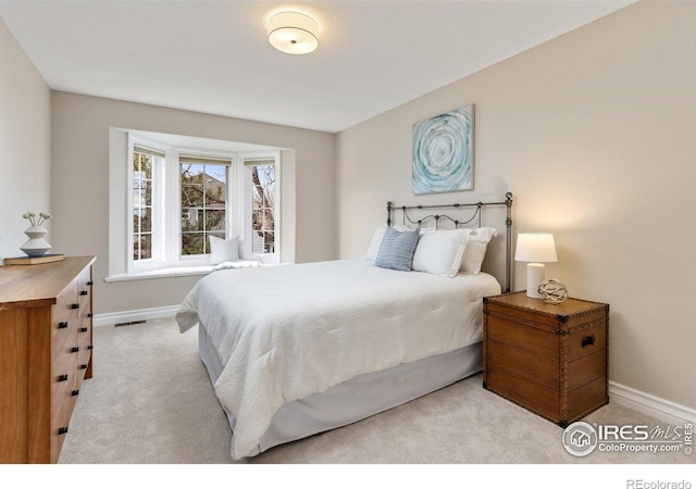 bedroom featuring visible vents, baseboards, and light colored carpet