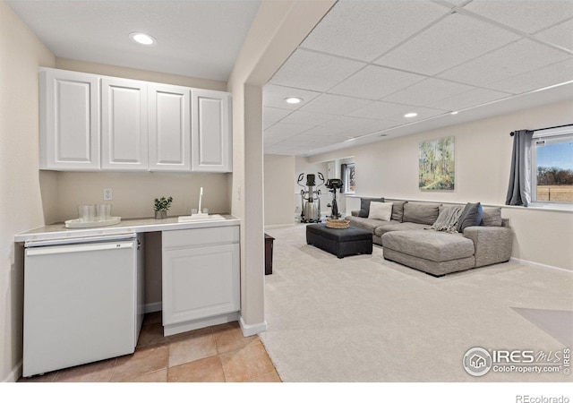 living area with a paneled ceiling, recessed lighting, baseboards, and light colored carpet