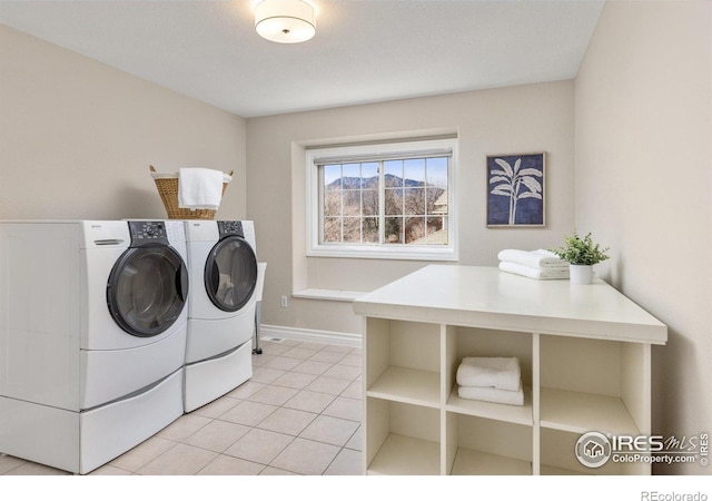 laundry area featuring laundry area, light tile patterned floors, baseboards, and separate washer and dryer