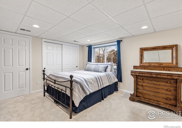 bedroom with baseboards, visible vents, a closet, and light colored carpet