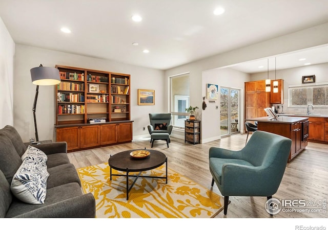 living area featuring light wood finished floors, baseboards, and recessed lighting