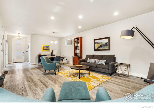 living area with recessed lighting, baseboards, visible vents, and light wood finished floors