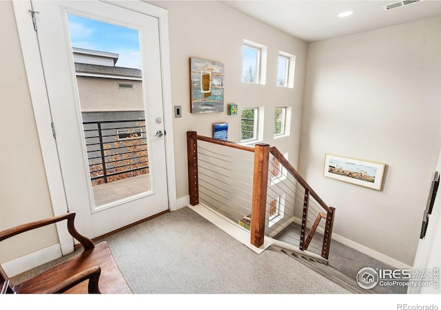 doorway featuring recessed lighting, carpet flooring, visible vents, and baseboards