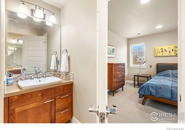 ensuite bathroom featuring baseboards, visible vents, connected bathroom, and vanity