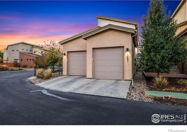 view of front of property with a garage, driveway, and stucco siding