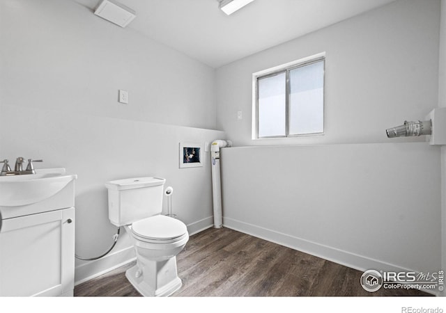 bathroom featuring baseboards, vanity, toilet, and wood finished floors