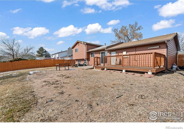 rear view of property with fence and a wooden deck