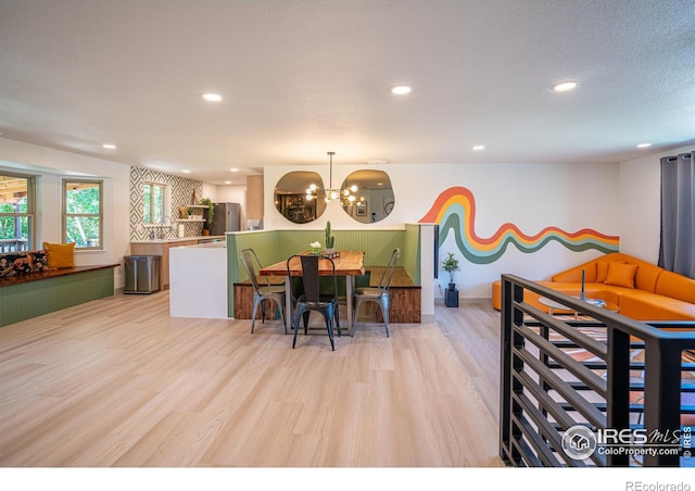 kitchen with recessed lighting, freestanding refrigerator, hanging light fixtures, and light wood finished floors