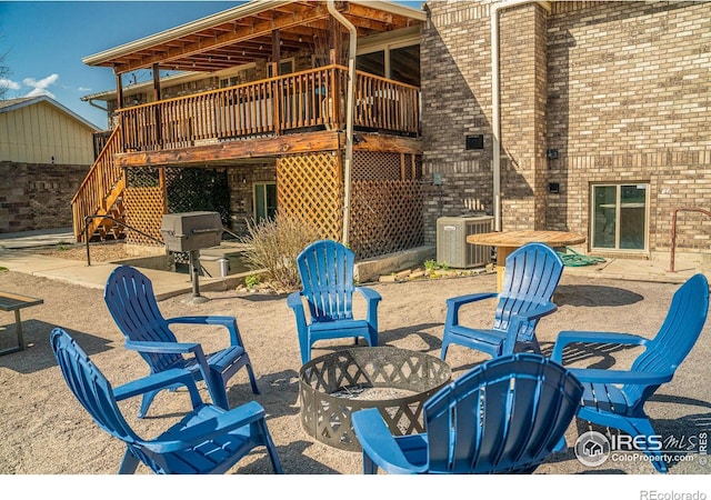 view of patio / terrace with stairs, an outdoor fire pit, cooling unit, and a wooden deck