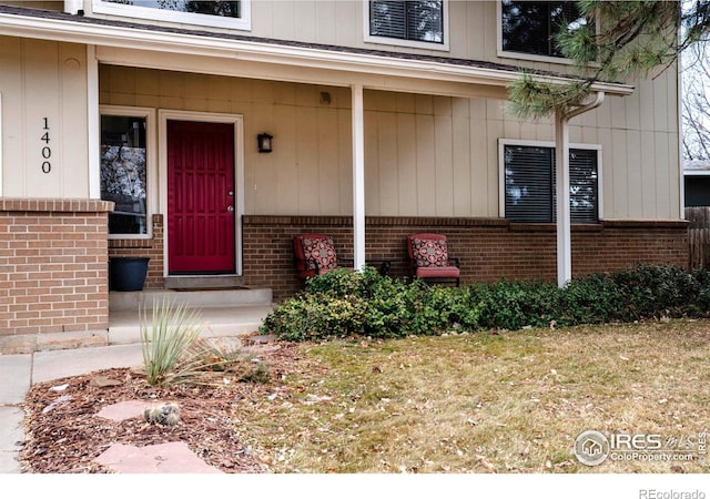 view of exterior entry featuring brick siding